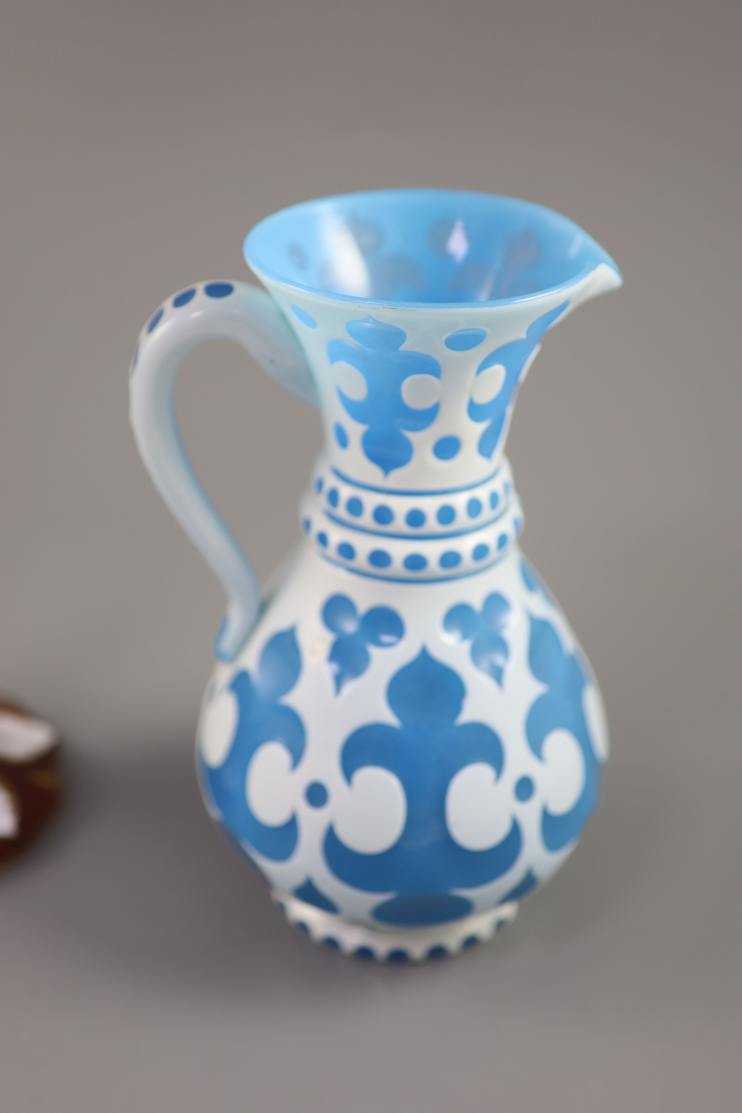A Bohemian blue and white overlaid glass jug and a similar ruby and white overlaid glass vase, tallest 35cm